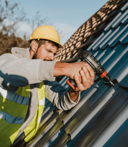 an electrician drilling the roof to set the roof tiles.