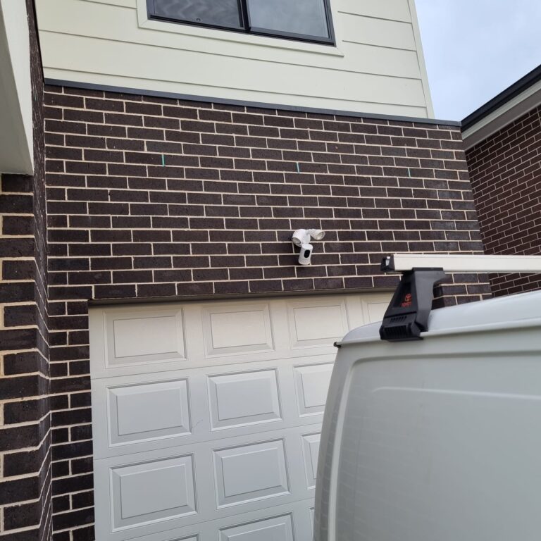 A house with a light and CCTV installed in the parking area by expert electricians to secure the property.