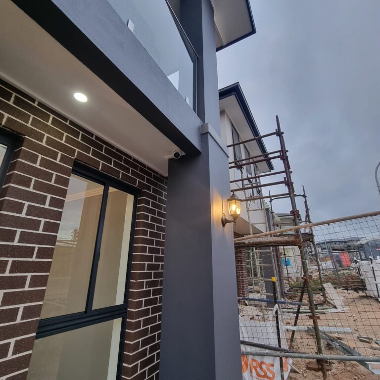 A nearly finished house with a Front light installed by an electrician, adding beauty and completing the look.