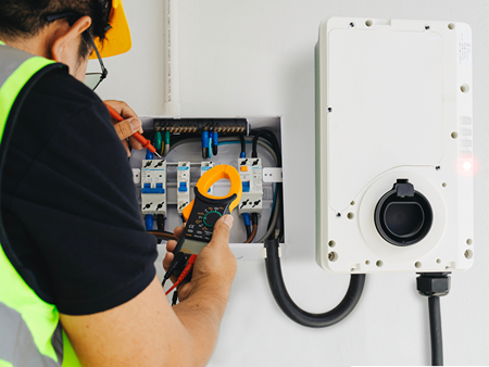 an expert electrician is checking the voltage in the multi-meter with the full safety.